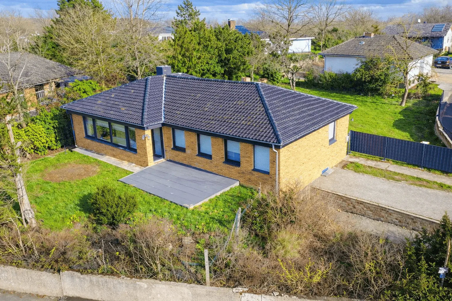 Außenansicht des Bungalows mit Terrasse und großem Grundstück